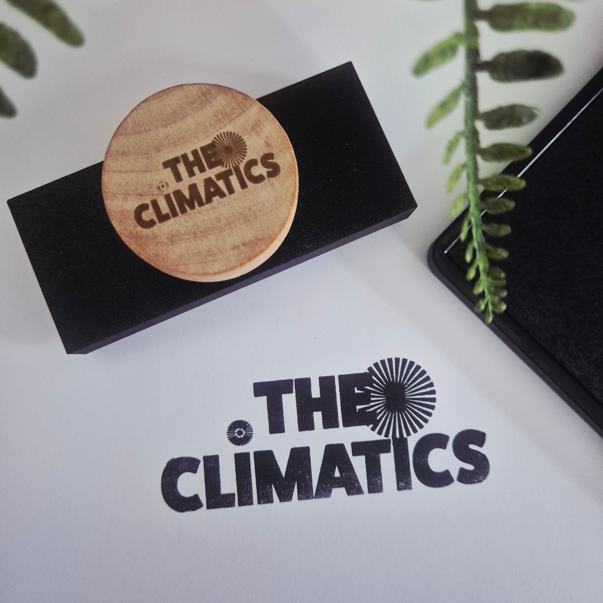 Black box with wooden disc featuring 'The Climatics' logo on a white background with the brand name printed.