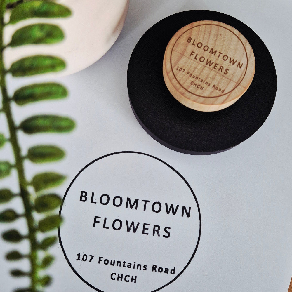 Branding stamp on a white surface with a black stamp block and engraved wooden handle