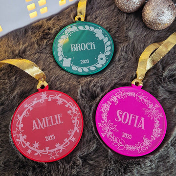 Decorative round ornaments with names on a textured surface