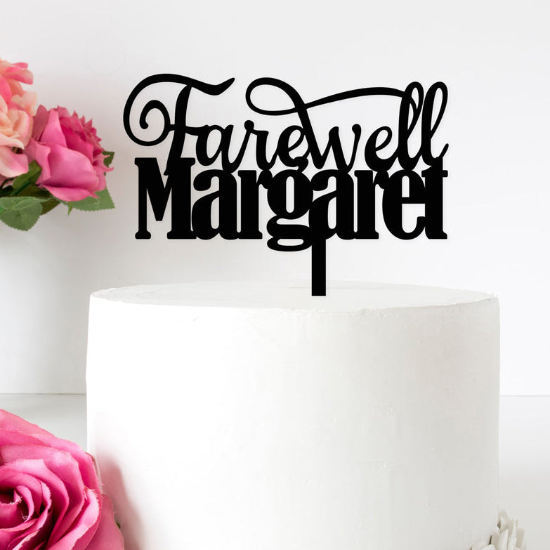 White cake with 'Farewell Margaret' topper and pink flowers on a white background
