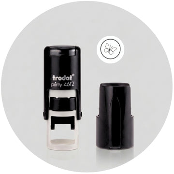 Trodat Printy 4612 self-inking stamp shown with its black cap removed, on a light gray background with a butterfly logo graphic.