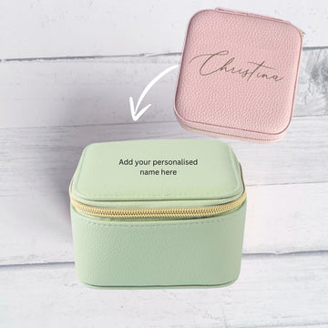 Green jewelry box with pink top on a white wooden surface, featuring the name 'Christina'.