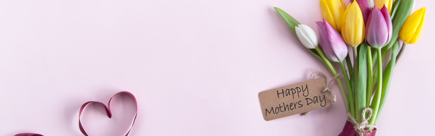 Bouquet of colorful tulips with a 'Happy Mother's Day' tag on a light pink background