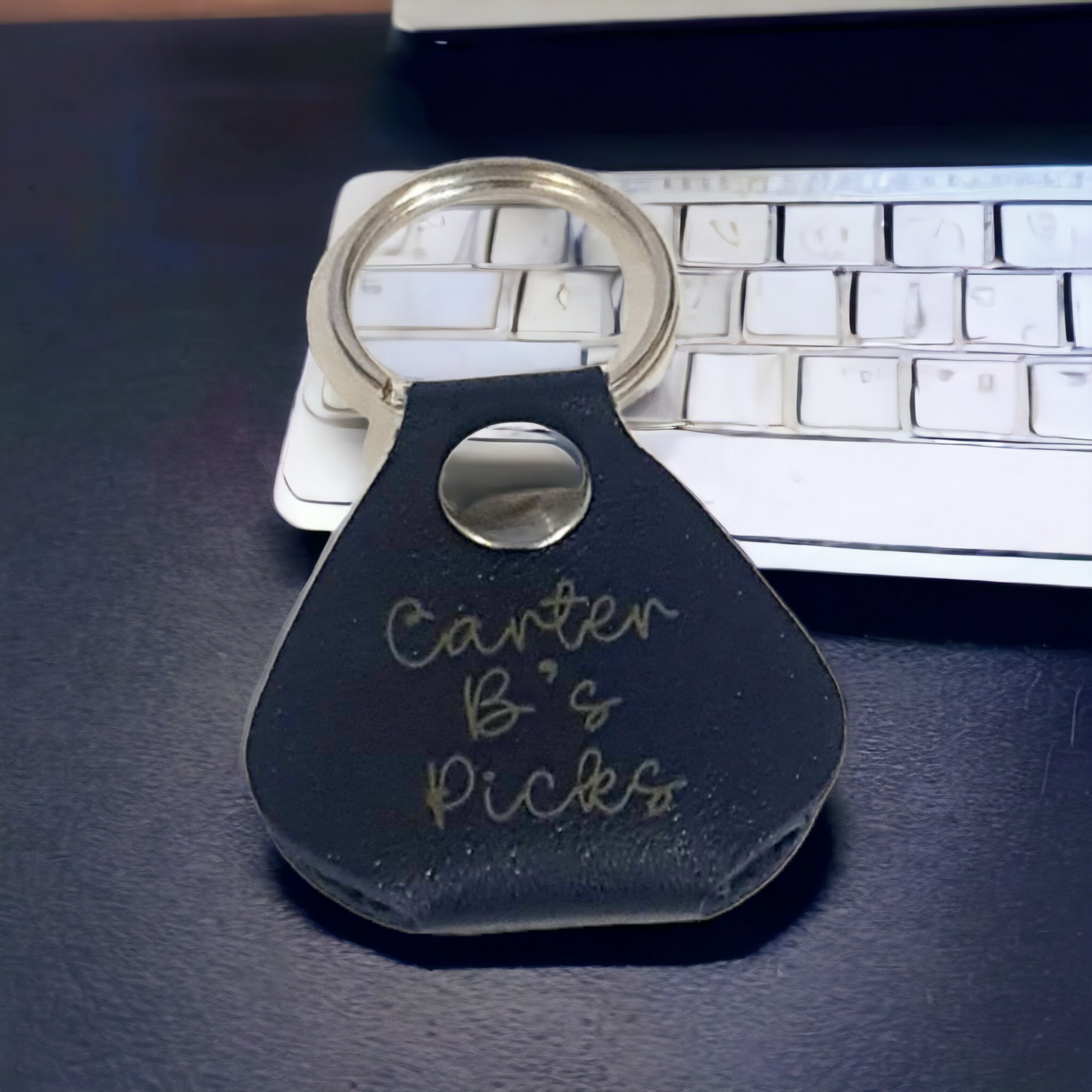 Image of blue guitar pic keyring laser engraved with a name