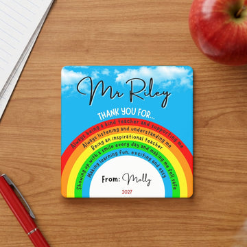 Bright blue sky and rainbow personalised ceramic teacher desk coaster featuring custom thank you messages written inside the colourful rainbow stripes.