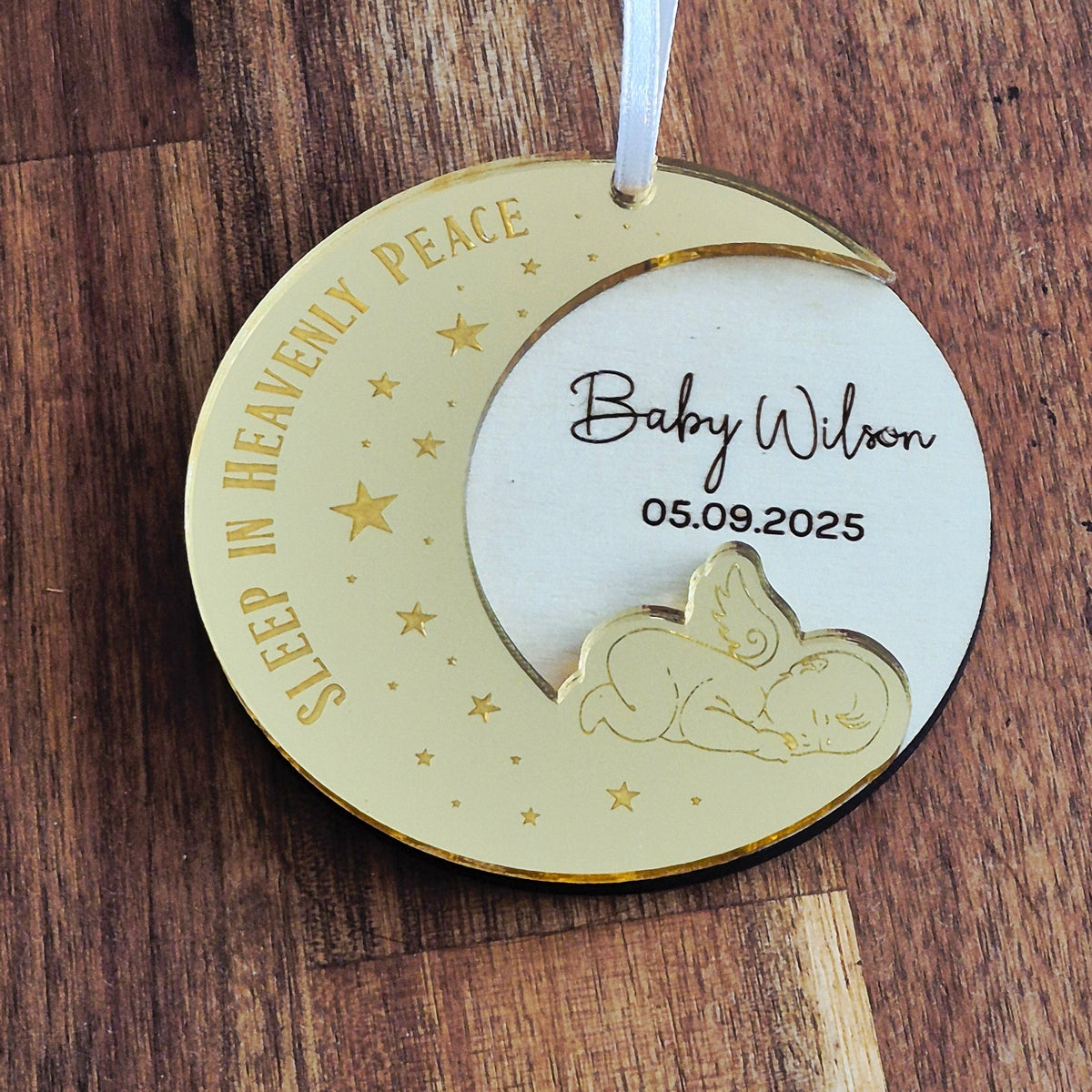 A personalised christmas ornament made of wood and gold mirror acrylic as a memorial to a lost baby