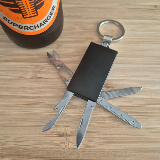 Black Keyring with scissors, ruler, nail file, bottle opener and knife. Can be custom engraved.