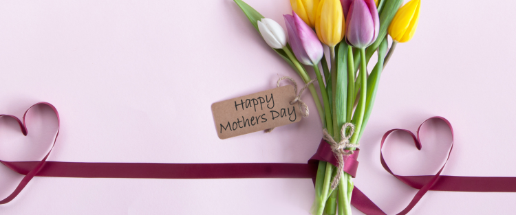 Bouquet of colorful tulips with a 'Happy Mother's Day' tag on a pink background